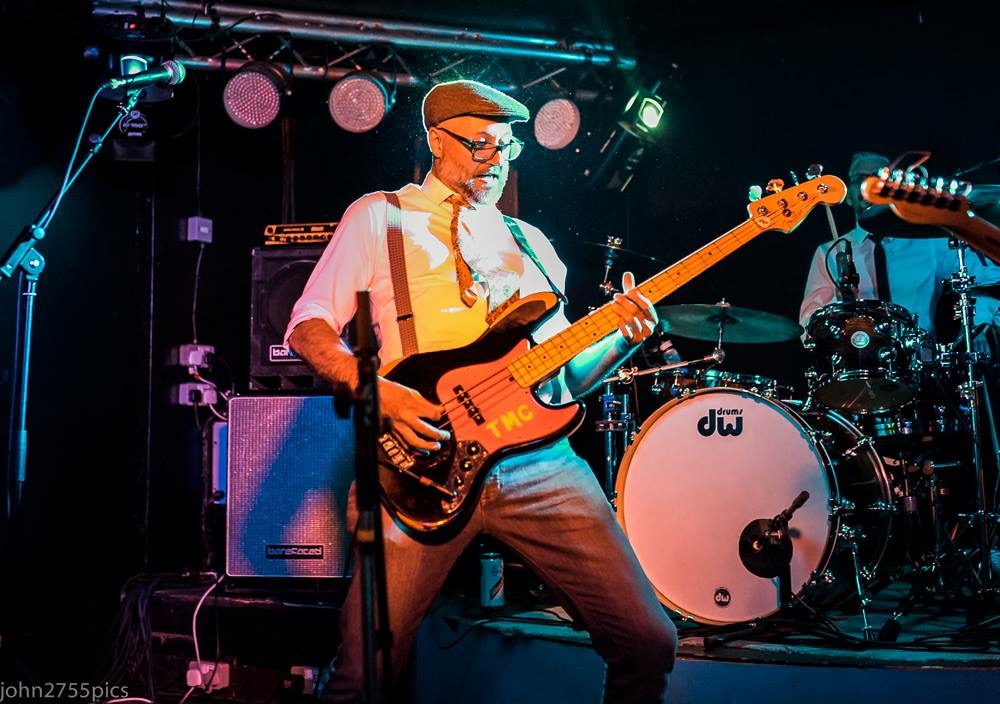 Image of a bassist and drummer in a live music setting