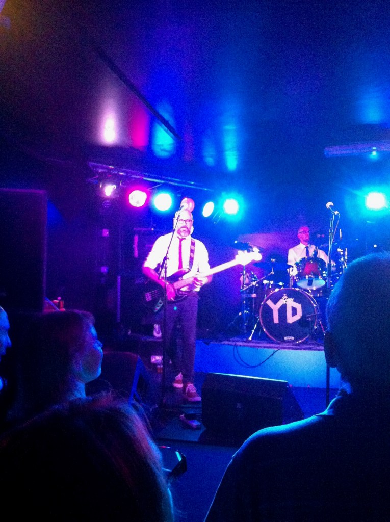 Image of a bassist and drummer in a live music setting